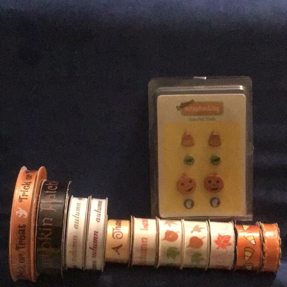 11 spools Fall/ Halloween themed ribbon and a set of brads